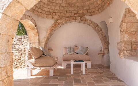Masseria Le Monache: Wand, Möbel, Steinwand, Backstein, Natürliches Material, Stuhl, Wohnzimmer, Zimmerpflanze, Kissen